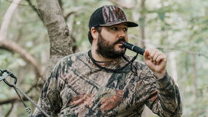 Man holding the IronBuck in a tree stand in the woods