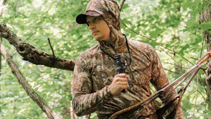 Hunter in camouflage gear with the IronBuck in a forest setting